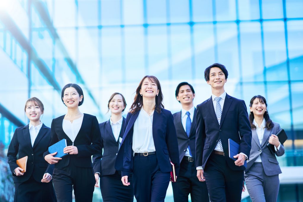 笑顔で歩く7人のビジネスパーソン