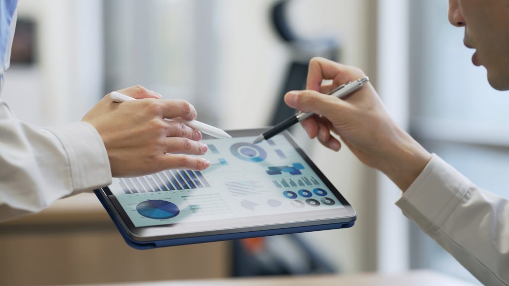 タブレットの画面を見ながら話す2人のビジネスパーソン