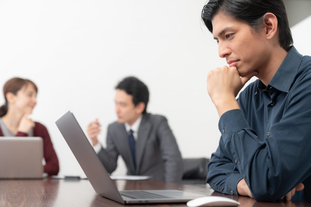 パソコンを見ながら悩むビジネスパーソン