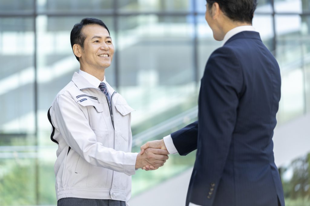 笑顔で握手をする2人のビジネスパーソン