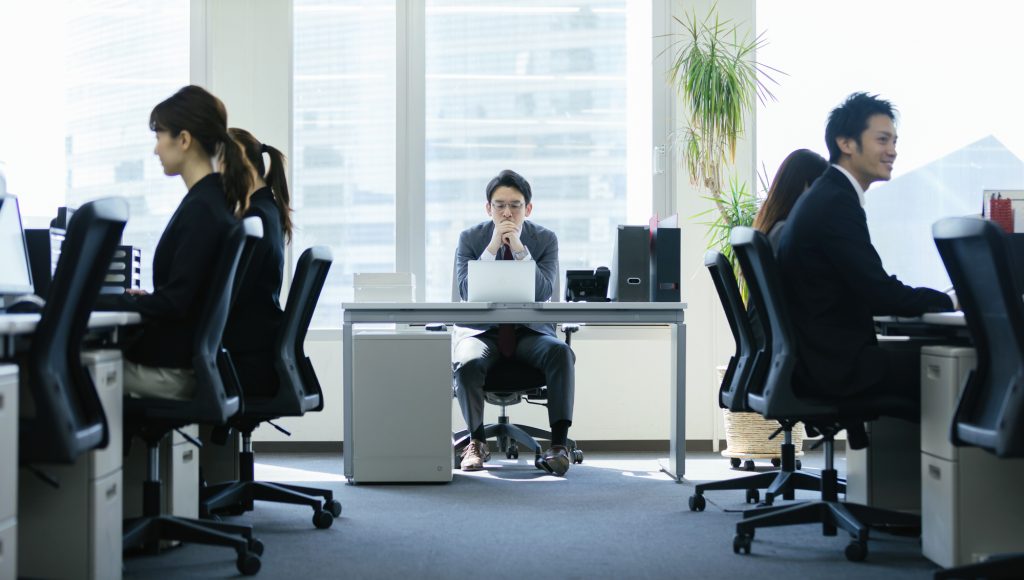 オフィスでデスクに座り悩むビジネスマン