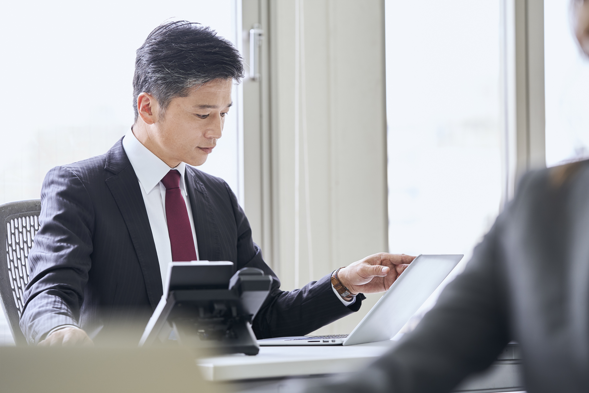 オフィスでパソコンを見るビジネスパーソン