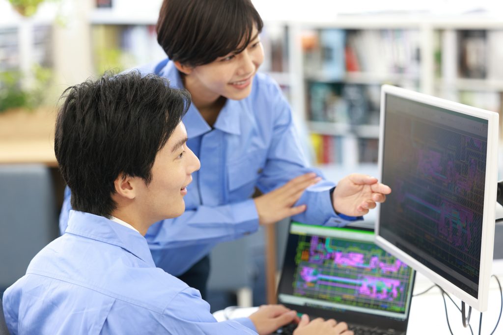 パソコンの画面を見ながら話をする2人のビジネスパーソン