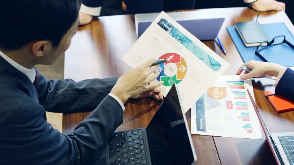 資料を見ながらミーティングするビジネスパーソン