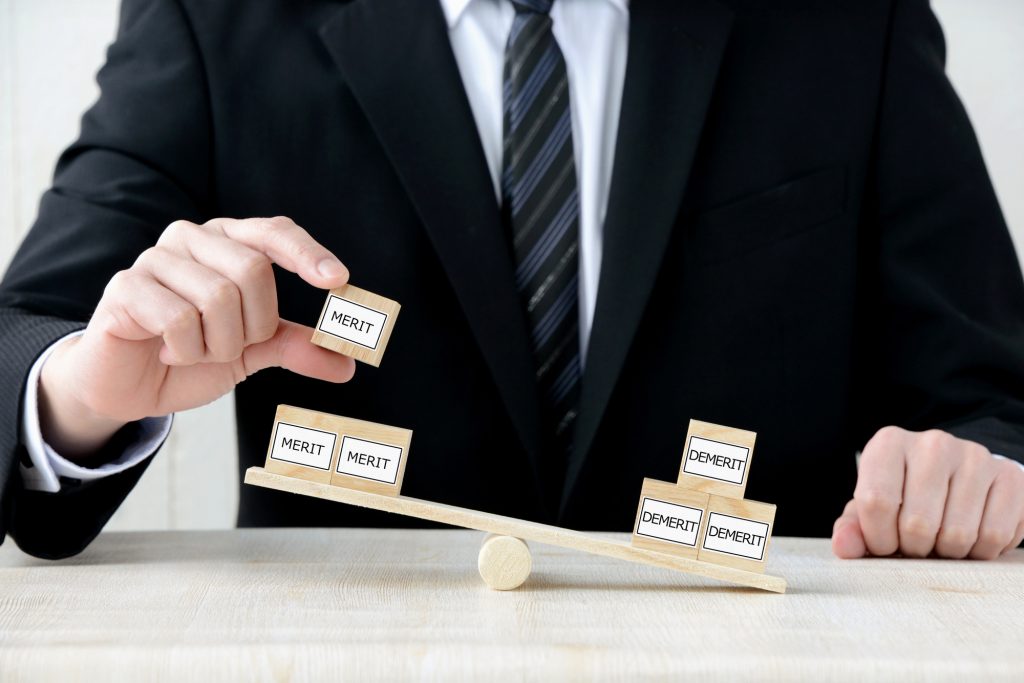 メリットとデメリットをはかりにかけるビジネスパーソン