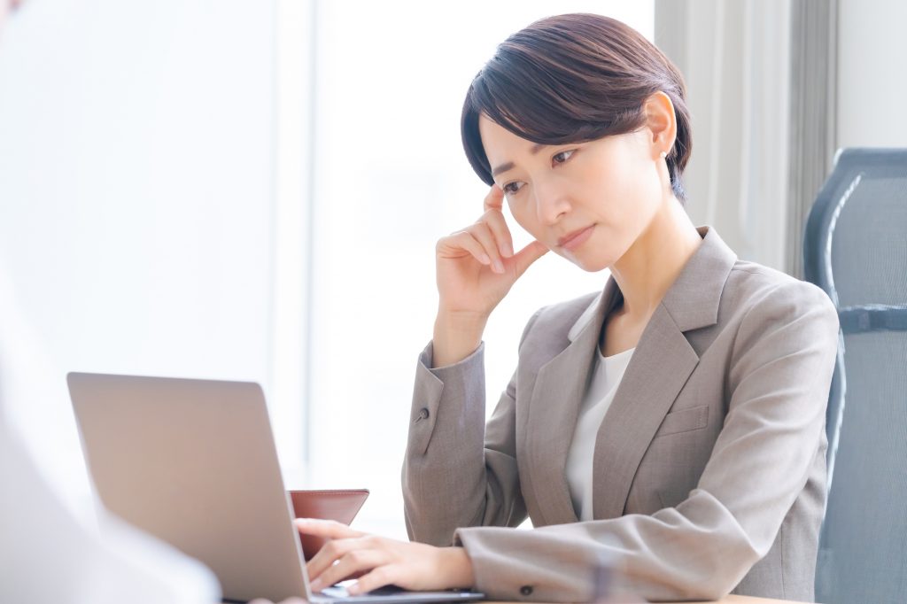 パソコンを前にして悩むビジネスパーソン