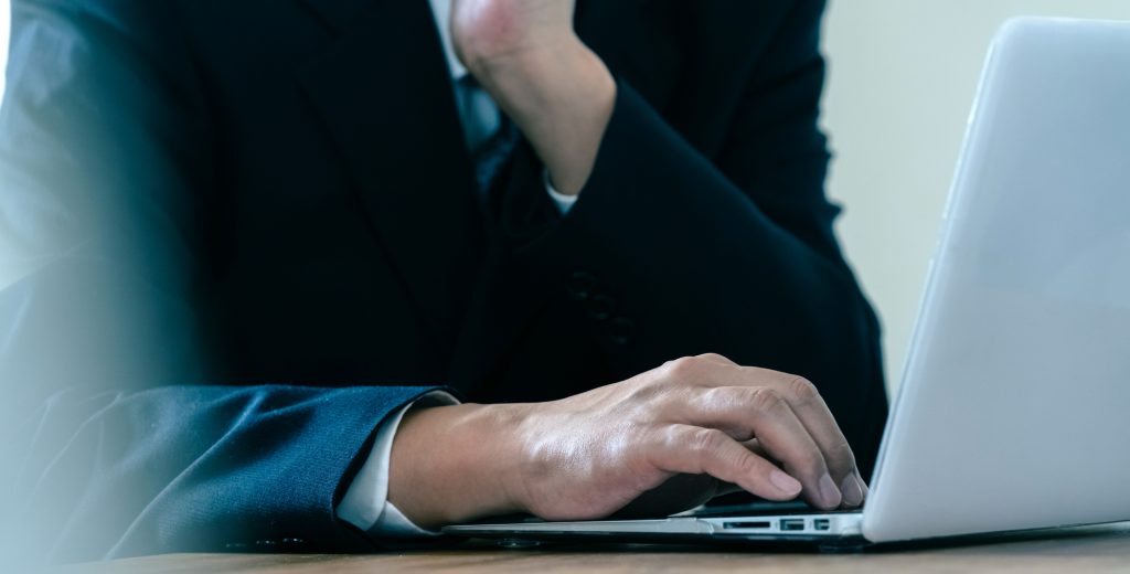 パソコンを見て悩むビジネスパーソン