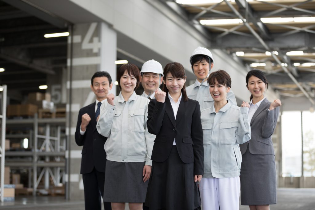 笑顔でガッツポーズをする7人のビジネスパーソン