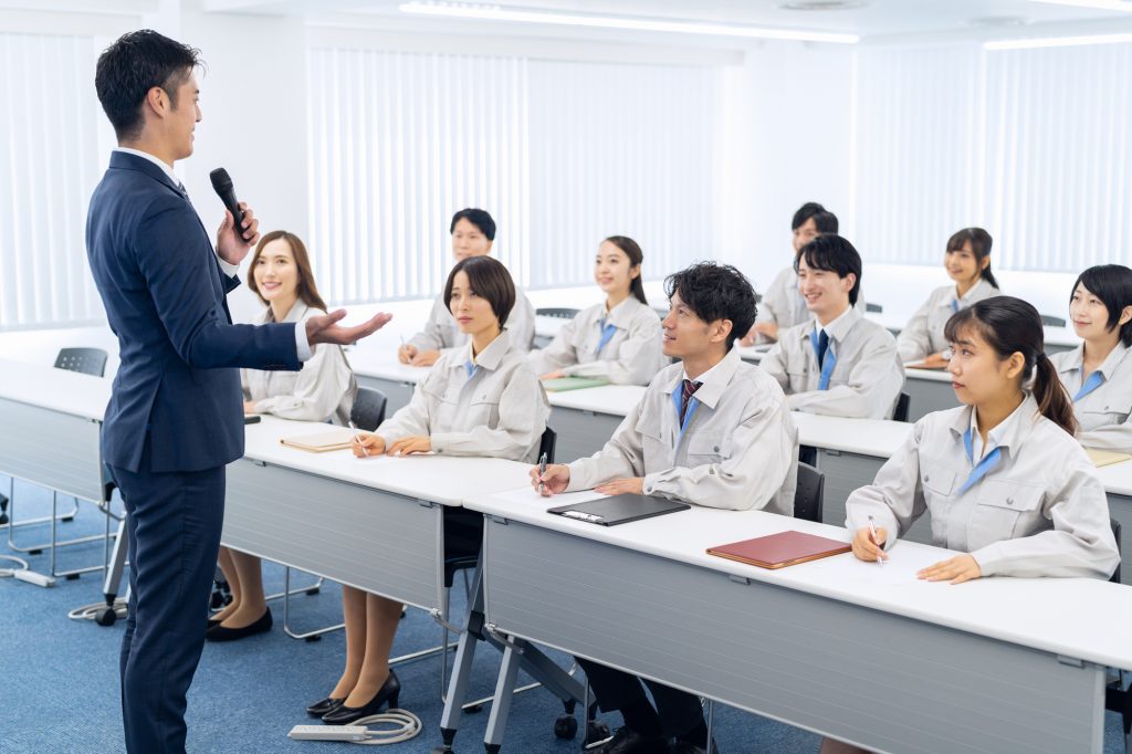 若手従業員を前にセミナーをする男性