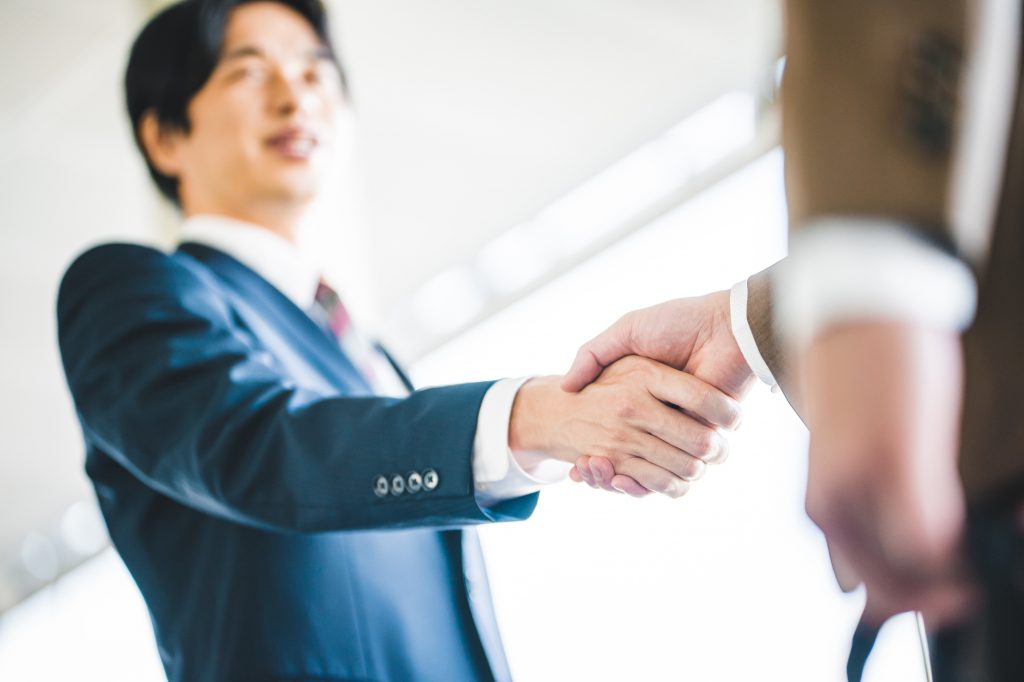 握手する2人のビジネスパーソンの手元