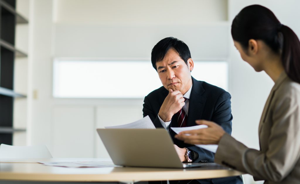パソコンを見ながら打ち合わせする2人のビジネスパーソン