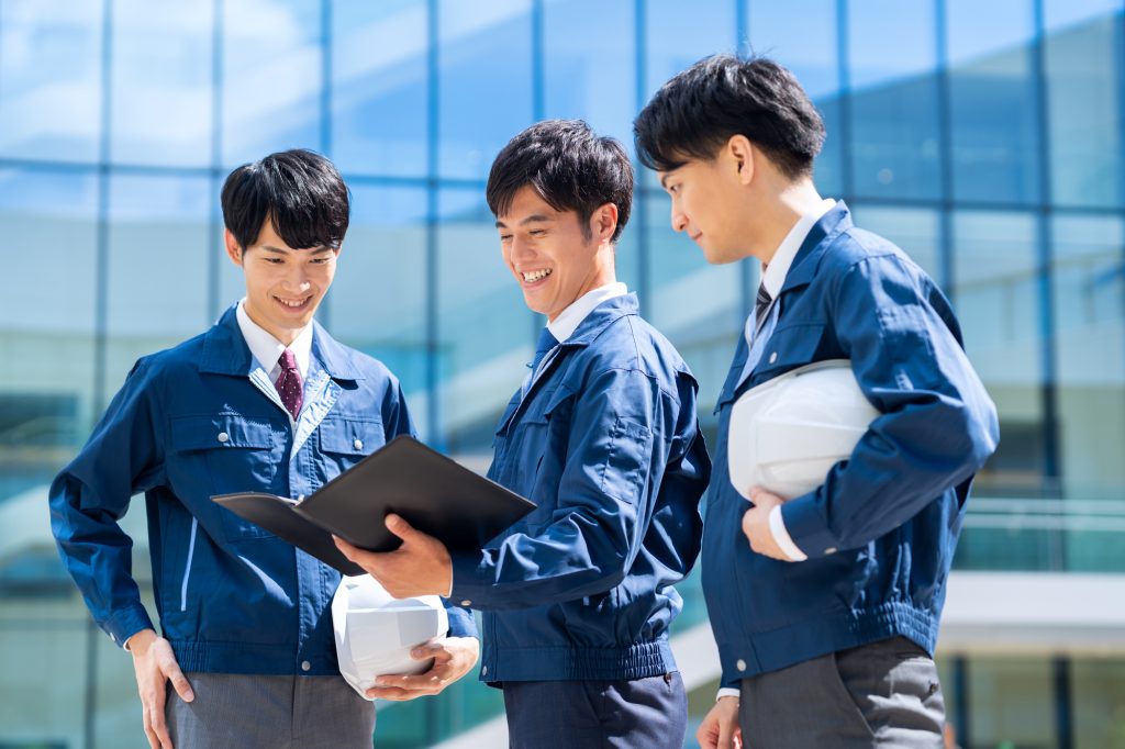 笑顔で資料を見る3人のビジネスパーソン