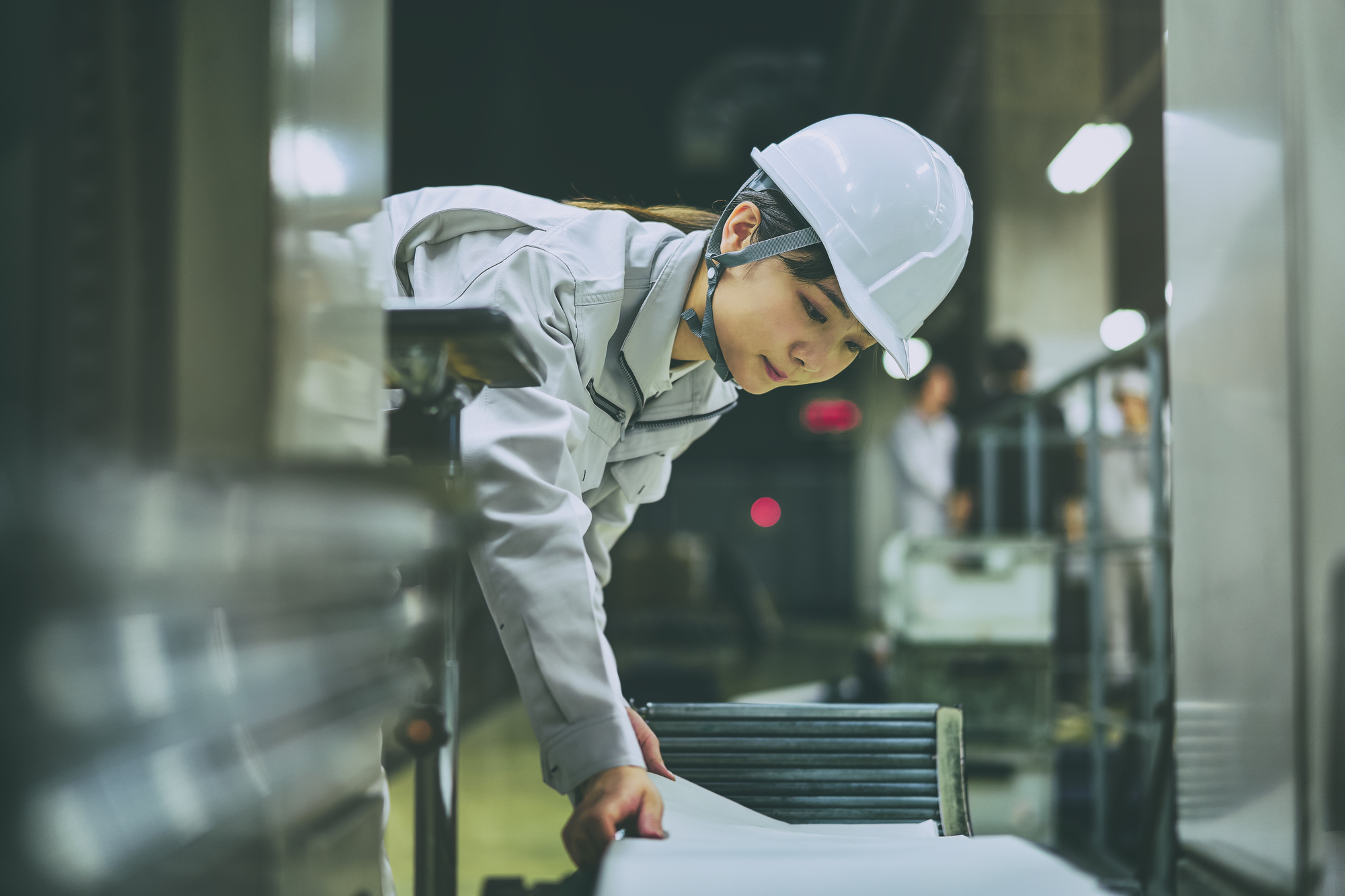 作業服にヘルメットを着けて働く女性