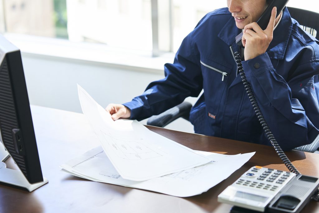 資料を見ながら電話するビジネスパーソン