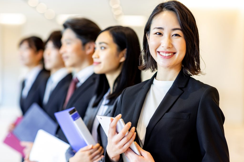 資料を手にほほ笑むビジネスパーソン