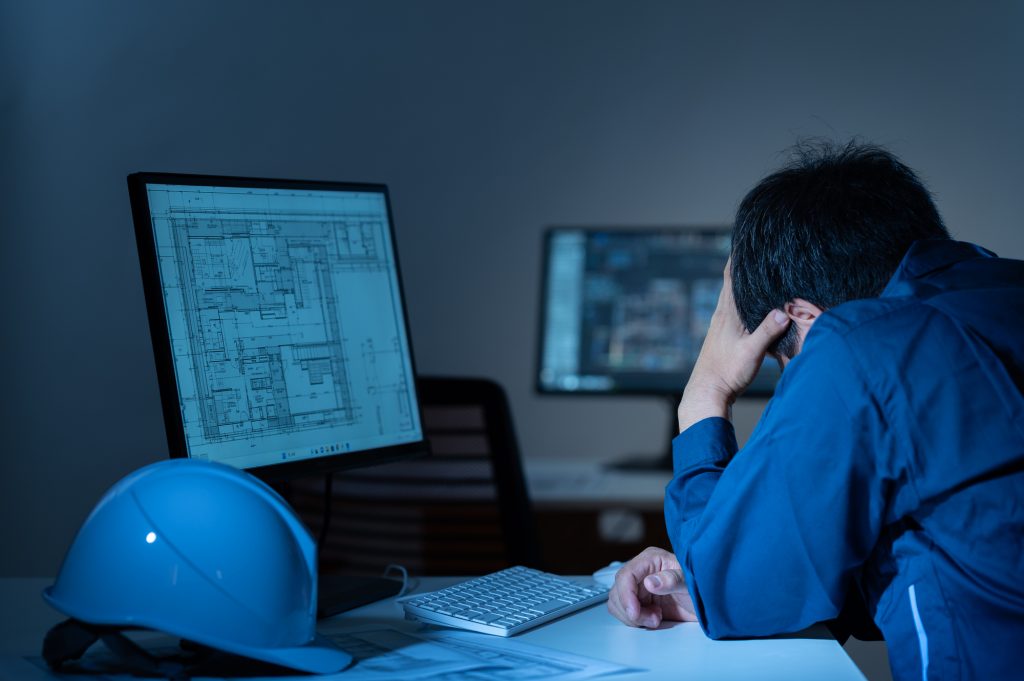 パソコンの画面を見ながら頭を抱えるビジネスパーソン