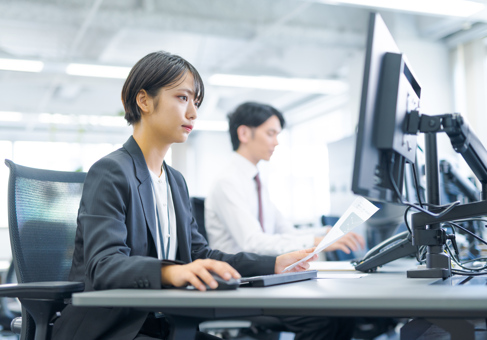 デスクで資料を見ながら作業をするビジネスパーソン