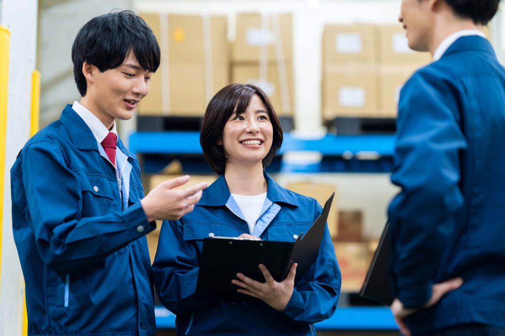 資料を見ながら笑顔で話す3人のビジネスパーソン