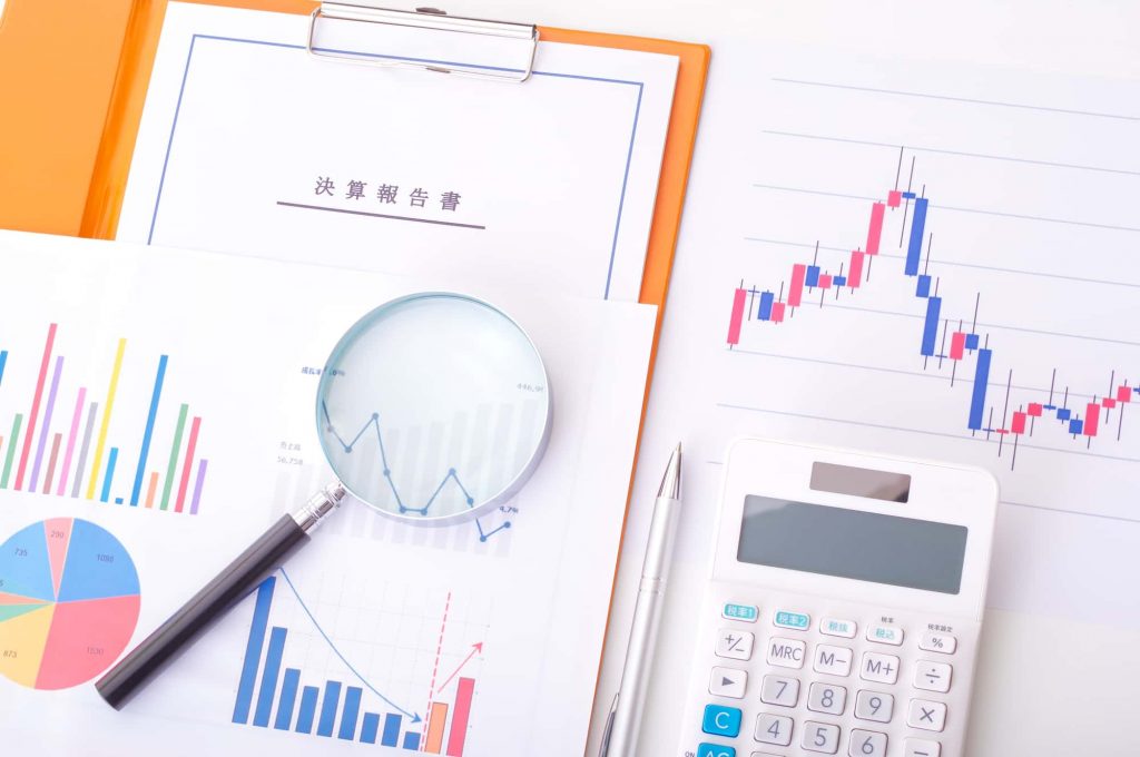 決算報告書と虫眼鏡と資料が置かれている様子