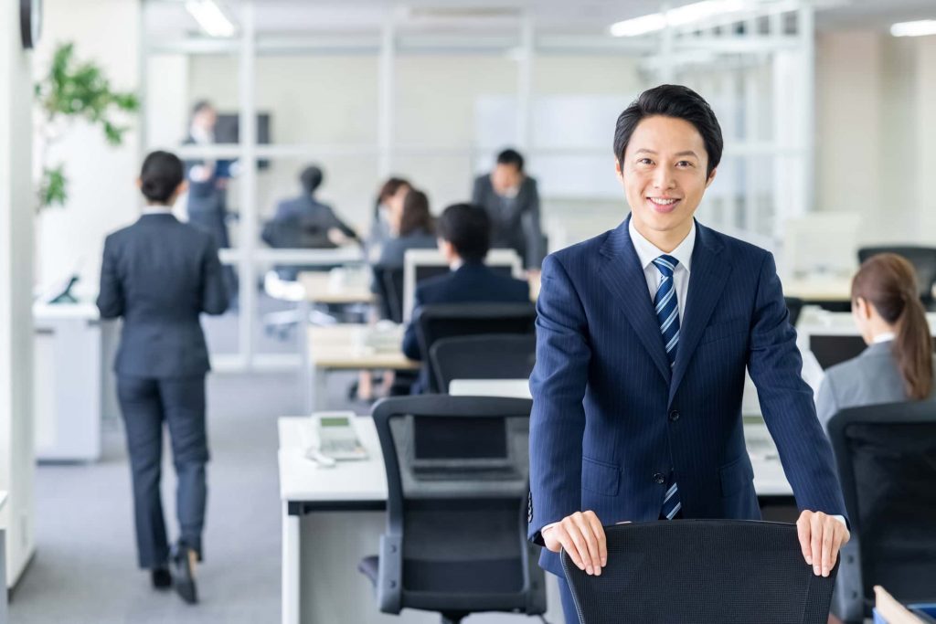 オフィスで笑顔で立つビジネスパーソン
