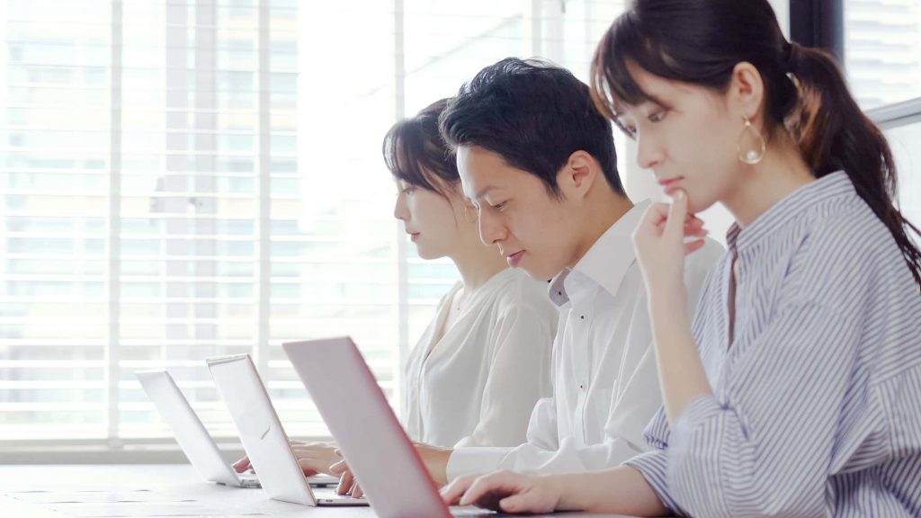 パソコン作業をする3人のビジネスパーソン