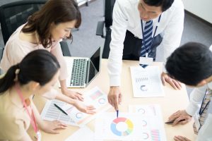 資料を見ながら会議するビジネスパーソン