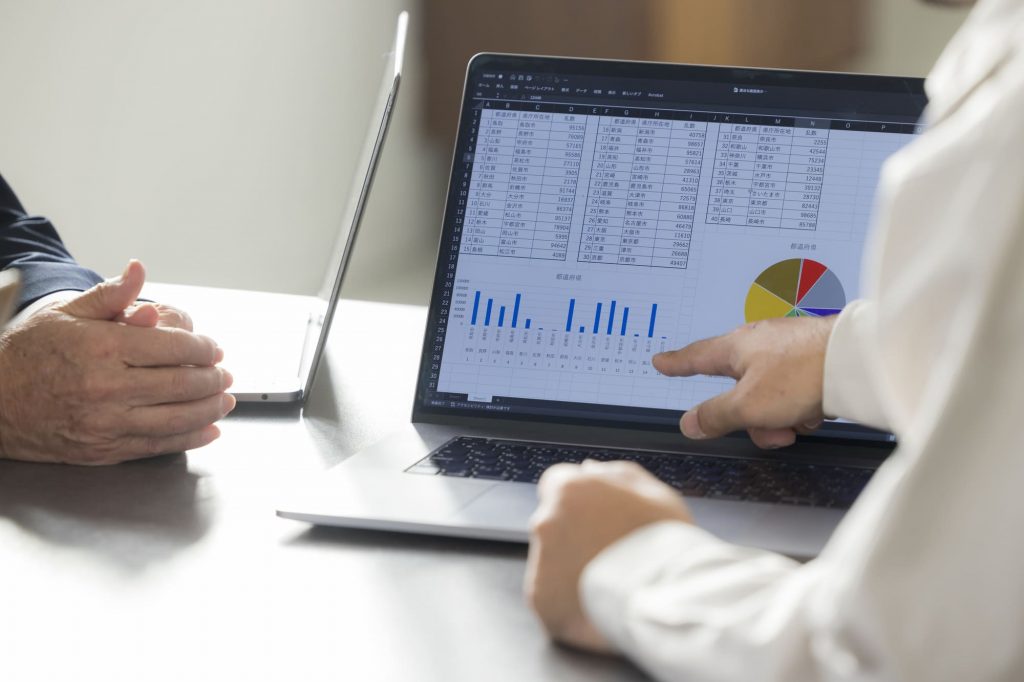 パソコンの資料を見ながらミーティングするビジネスパーソンの手元