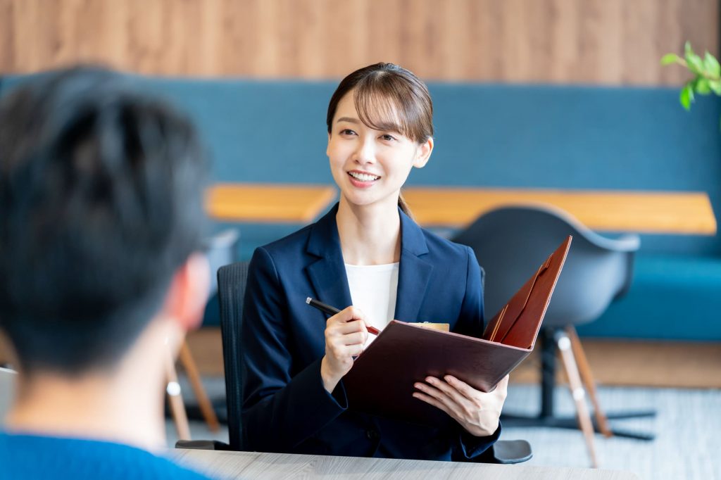 資料を見ながら笑顔でミーティングするビジネスパーソン