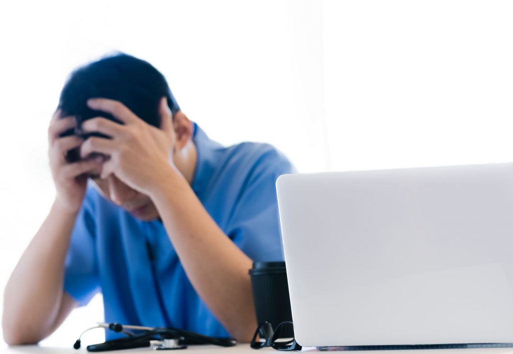 デスクで頭を抱える男性