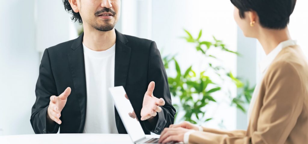 オフィスで会話する2人のビジネスパーソン