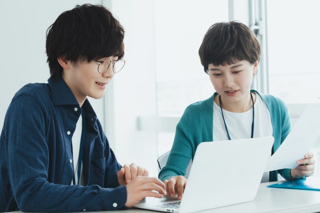 パソコン作業をする2人のビジネスパーソン