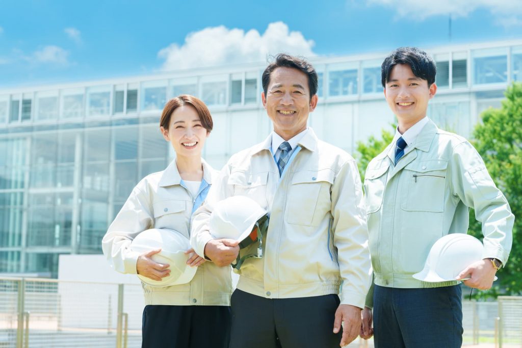 笑顔で立つ3人のビジネスパーソン