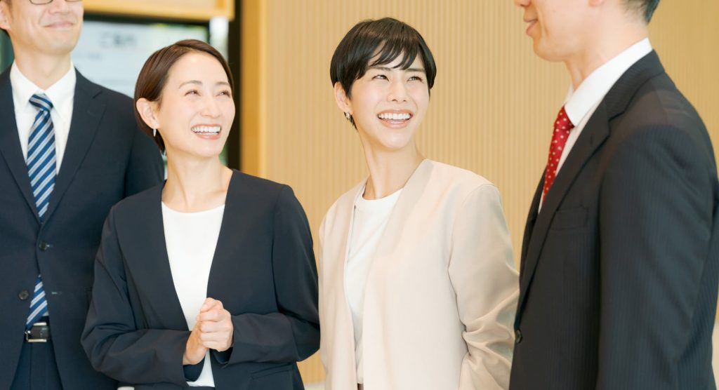 笑顔で話す4人のビジネスパーソン