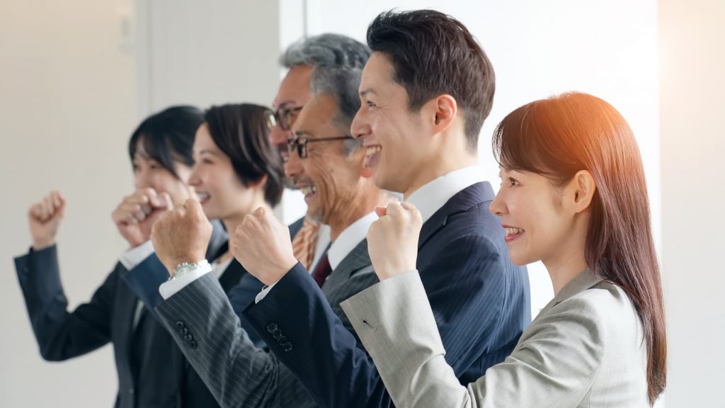 笑顔でガッツポーズをするビジネスパーソン