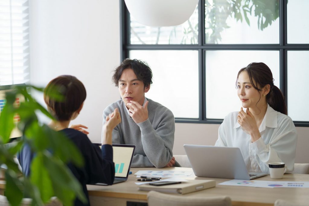 オフィスでミーティングする3人のビジネスパーソン