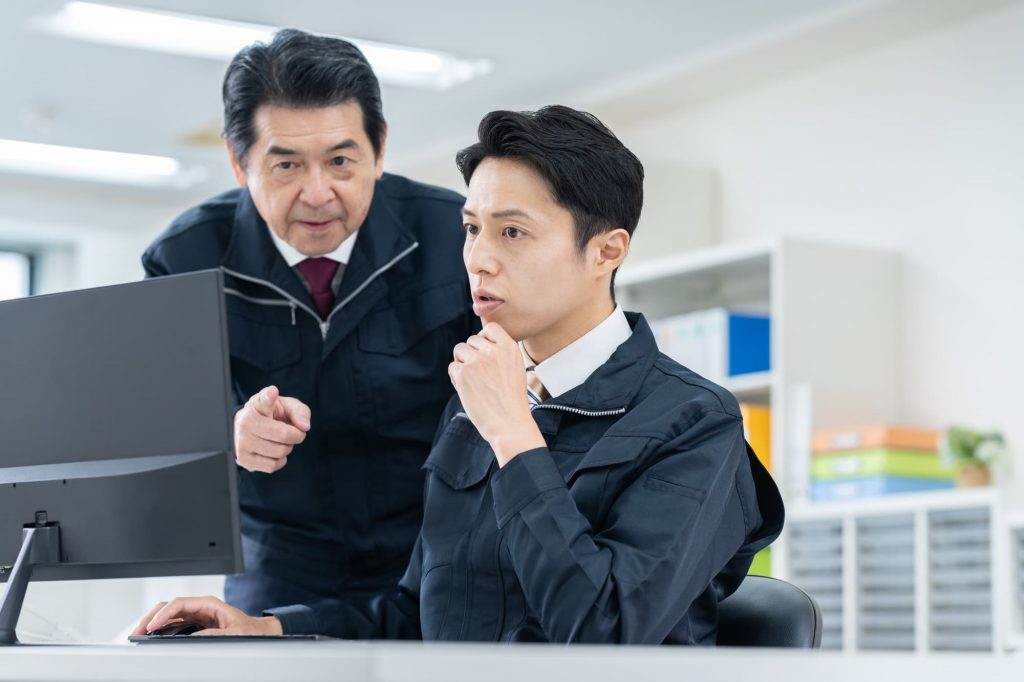 パソコンを見ながら話す2人のビジネスパーソン