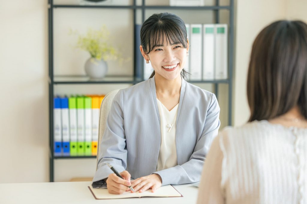 メモを取りながら打ち合わせをするビジネスパーソン