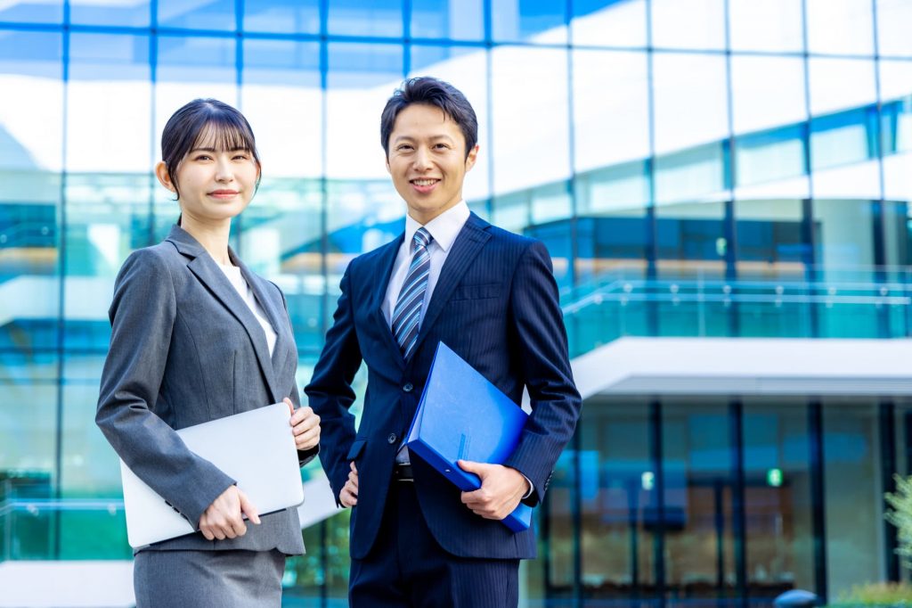 オフィスの前に立つ2人のビジネスパーソン