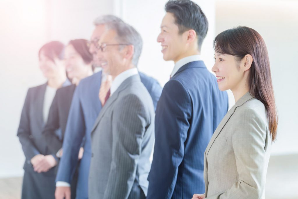 笑顔で立つ6人のビジネスパーソン
