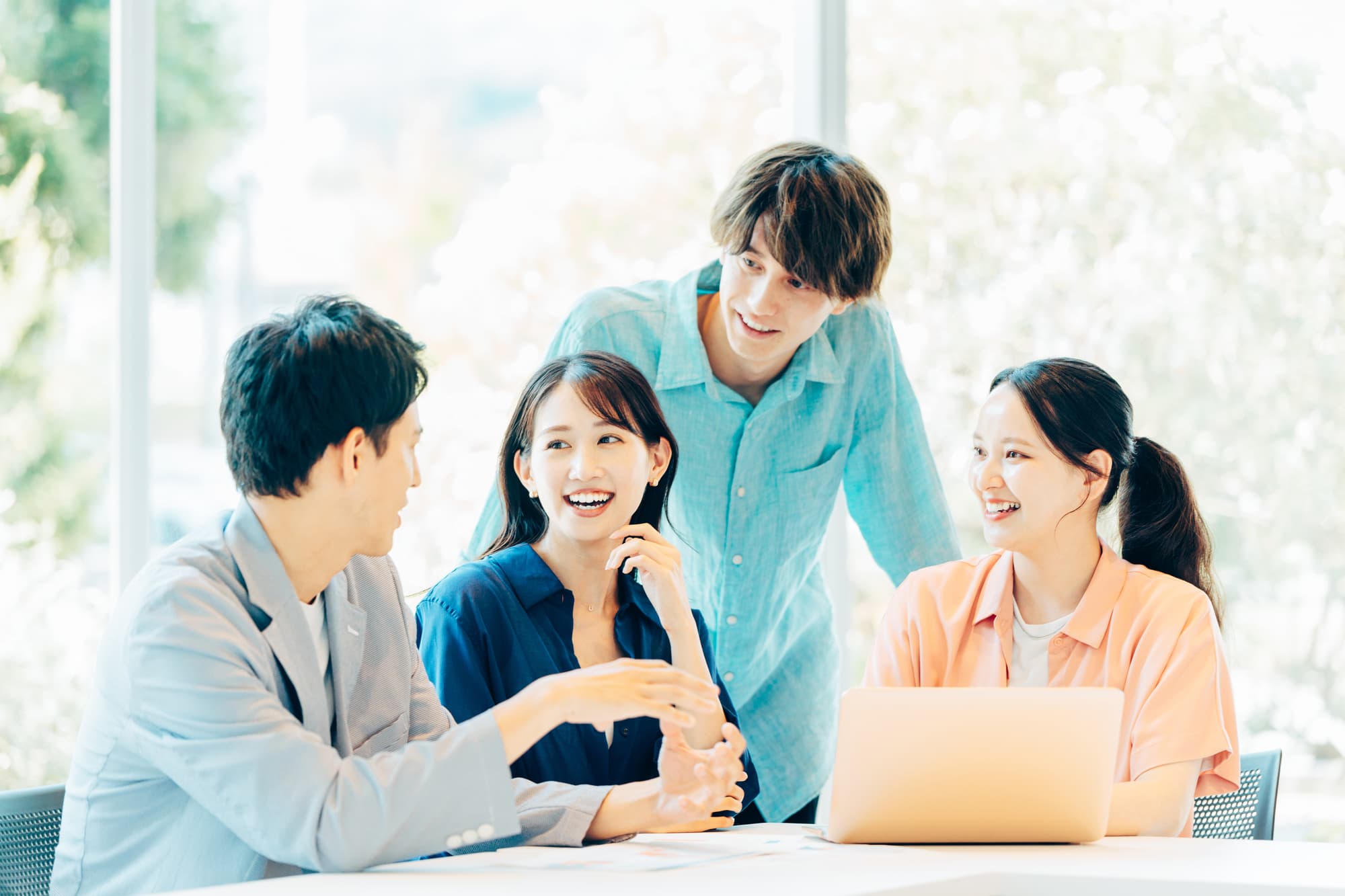 オフィスで打ち合わせをする4人のビジネスパーソン