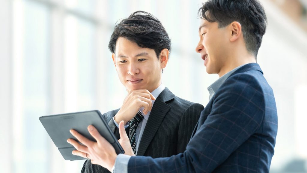 タブレットを持って打ち合わせをする2人のビジネスパーソン